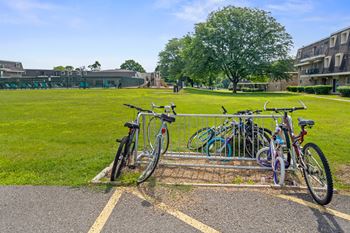A bike rack with several bicycles parked in front of a building.